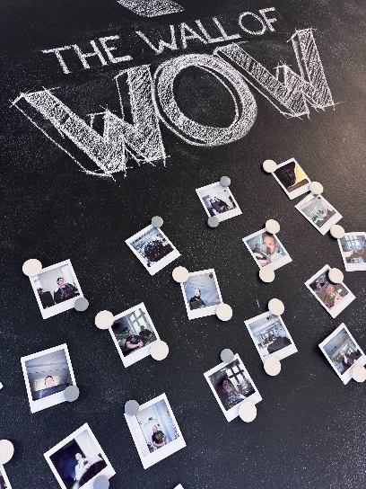 A wall labeled „Wall of Wow" with a collage of portrait photos.